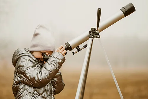 Niña con un telescopio